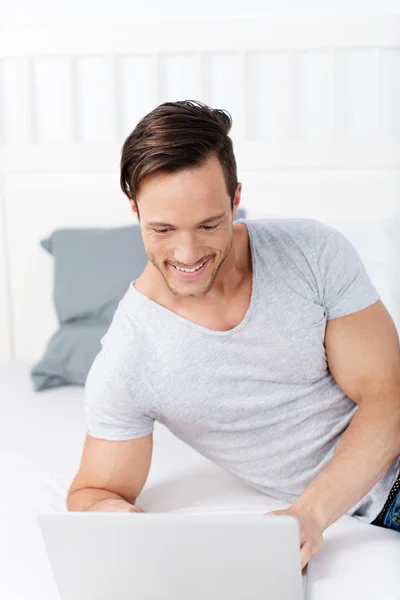 Smiling man with laptop — Stock Photo, Image