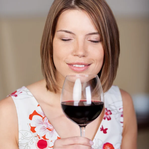 Mulher atraente desfrutando de vinho tinto — Fotografia de Stock