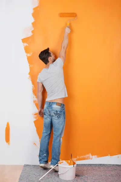 Человек рисует стену — стоковое фото