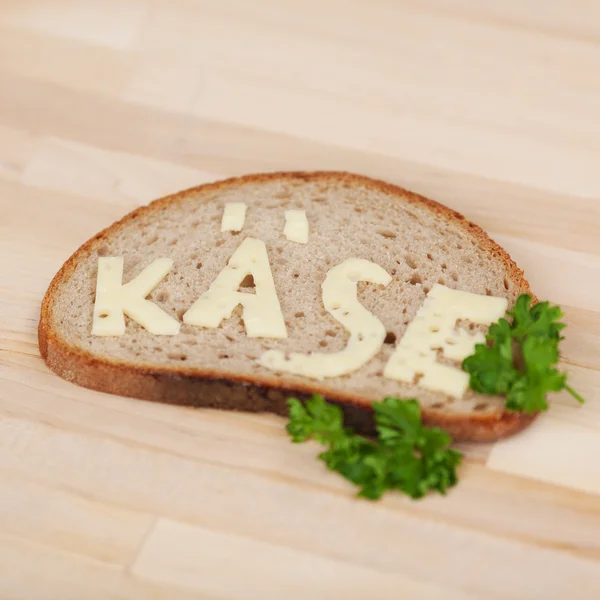 Rebanada de pan con la palabra Queso escrita en ella — Foto de Stock