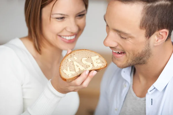 Casal feliz segurando uma fatia de pão e queijo — Fotografia de Stock