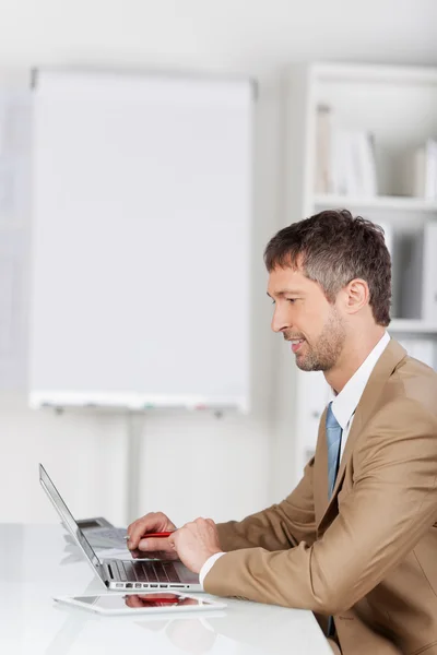 Mogna affärsman med laptop på skrivbordet — Stockfoto