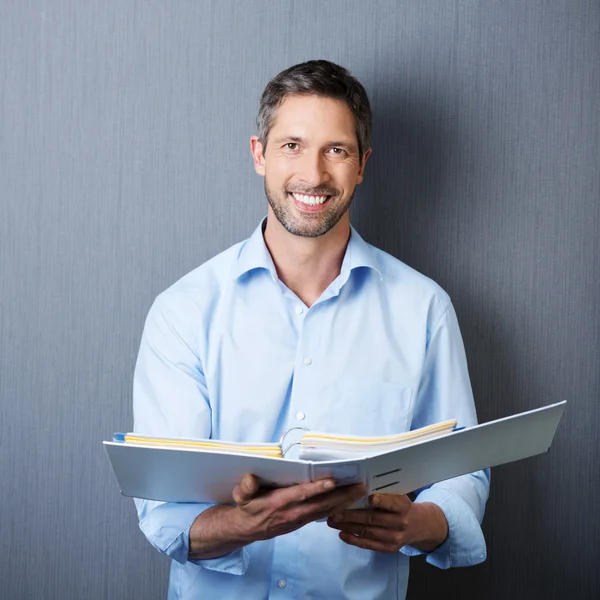 Affärsman hålla binder mot blå vägg — Stockfoto