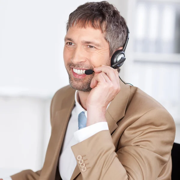 Ejecutivo de servicio al cliente feliz conversando en auriculares — Foto de Stock