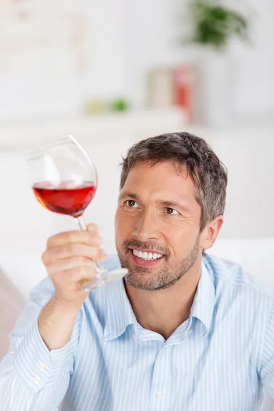 ワイングラスを自宅で見て成熟した男 — ストック写真