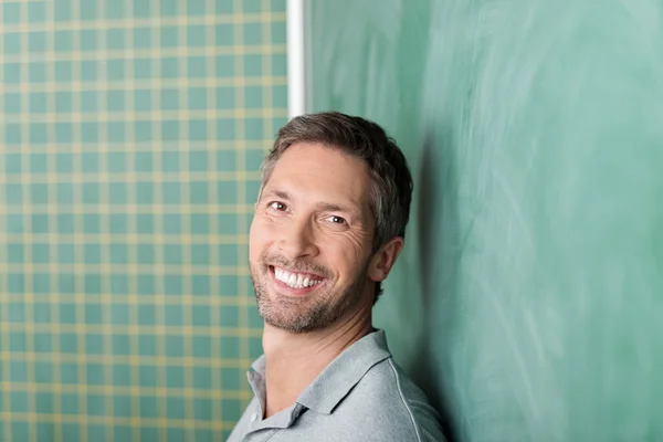 Happy Teacher Against Blackboard Stock Photo