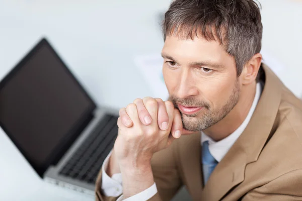 Thoughtful Businessman With Laptop At Desk — Stock Photo, Image