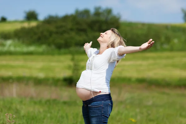 Pregnant Woman With Arms Outstretched At Field — Stock Photo, Image