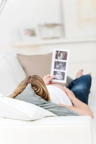 Těhotná žena drží babys ultrazvukem — Stock fotografie