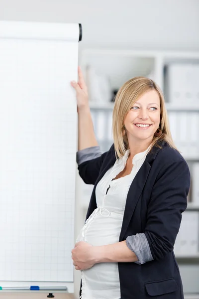 Ευτυχής επιχειρηματίας έγκυος με τα χέρια στην κοιλιά στέκεται κοντά σε πινακάκι — Φωτογραφία Αρχείου