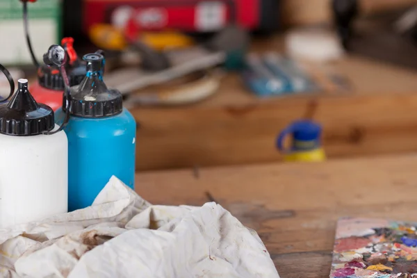 Paint Bottles And Cloth On Table At Workshop — Stock Photo, Image