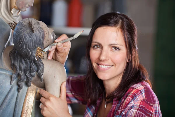 Χαμογελώντας καθαρισμού άγαλμα γυναίκα καλλιτέχνης με σπάτουλα — Φωτογραφία Αρχείου