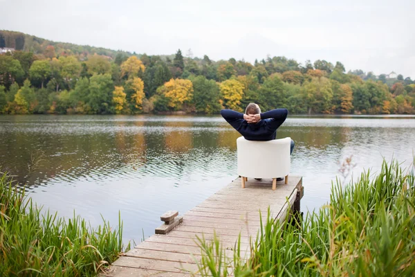 Bărbat cu mâinile în spatele capului relaxându-se pe scaun la Pier — Fotografie, imagine de stoc