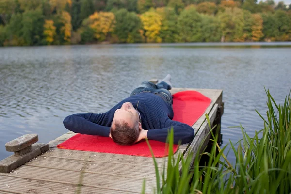 Man Lying On Pier Against Lake — Stock Photo, Image