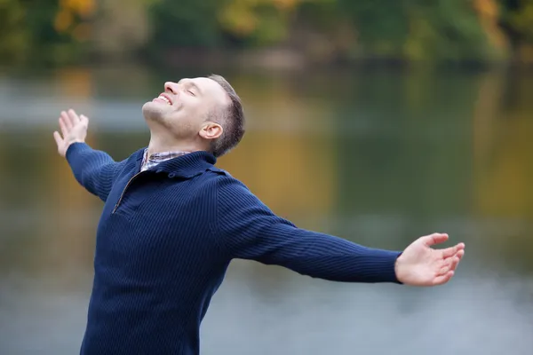 Man met armen gestrekt buiten — Stockfoto