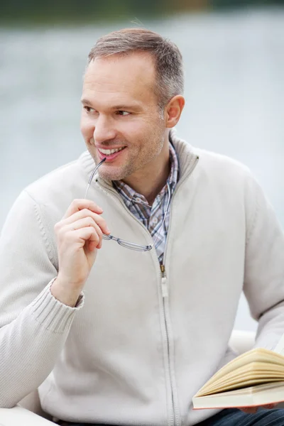 Man Holding Glasses And Book While Looking Away — Stock Photo, Image