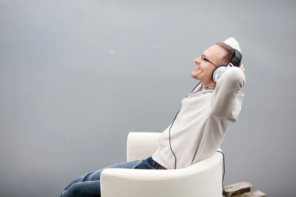 Homem ouvindo Musing através de fones de ouvido no cais — Fotografia de Stock