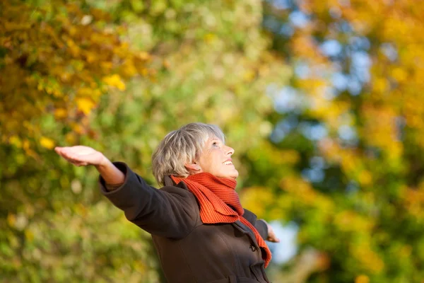 Happy senior kvinna njuter av naturen i park — Stockfoto