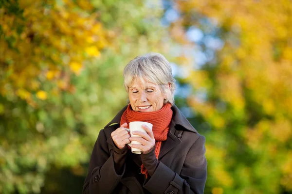 Ανώτερος γυναίκα, απολαμβάνοντας καφέ στο πάρκο — Φωτογραφία Αρχείου