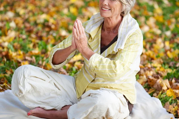 Mulher com as mãos apertadas meditando no parque — Fotografia de Stock