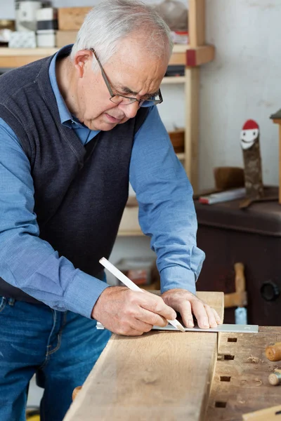 Muž měření pomocí stupnice na dřevo — Stock fotografie