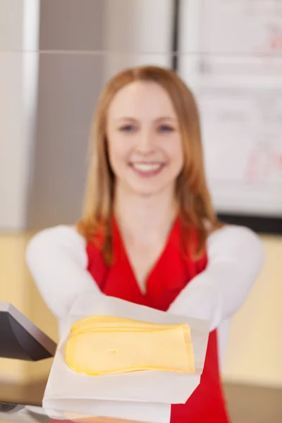 Friendly saleswoman showing sliced cheese — Stock Photo, Image