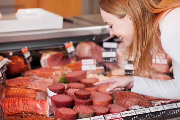 Mulher que escolhe a carne da seção refrigerada do supermercado — Fotografia de Stock