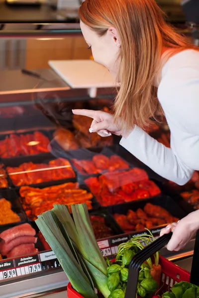 Frau kauft Fleisch im Feinkostladen — Stockfoto