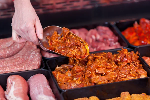 La mano de la mujer sosteniendo la cucharada de carne en el supermercado — Foto de Stock