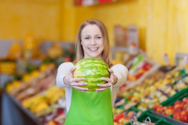 Glad kvinnlig arbetare håller vattenmelon i livsmedelsbutik — Stockfoto