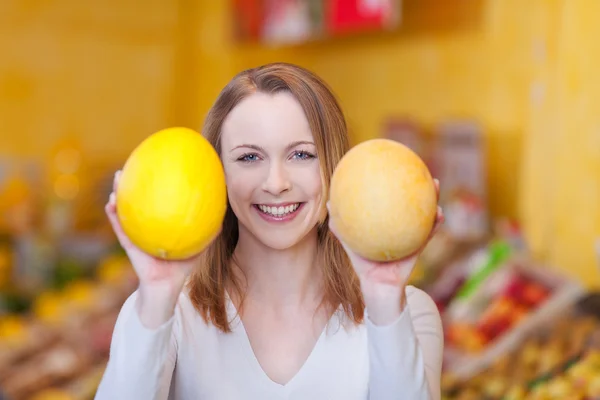 Femme avec un doux sourire montrant des melons — Photo