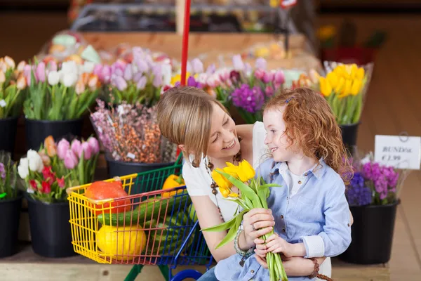 Mosolyog, anya és lánya vásárol tulipán — Stock Fotó