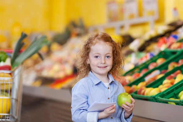 Beautiful little redhead girl with an apple — Stock Photo, Image