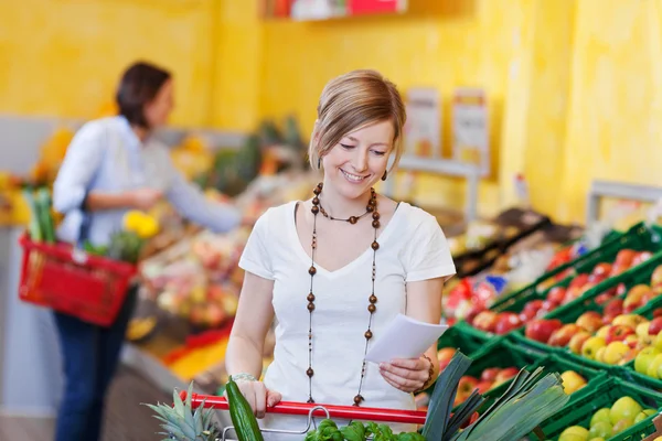 Kadınla bir süpermarkette alışveriş listesi — Stok fotoğraf