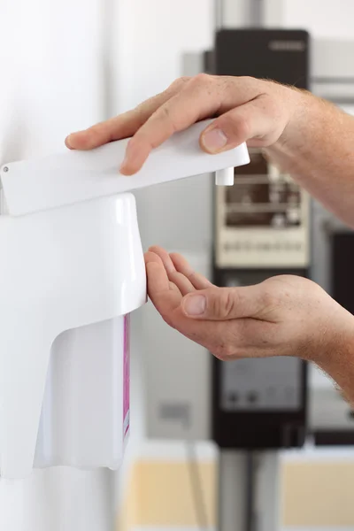 Tandläkarens händer använder Tvåldispenser i kliniken — Stockfoto