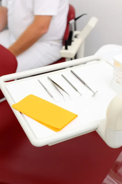 Ferramentas na bandeja com dentista sentado no fundo — Fotografia de Stock