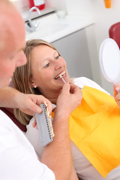 Dentista e paziente che confronta i denti guardando nello specchio — Foto Stock