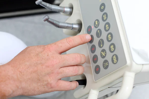 Mano del dentista premendo il pulsante sulla macchina — Foto Stock