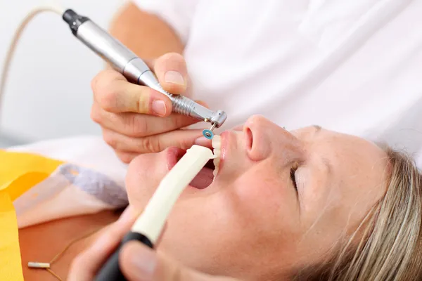 Dentista usando broca na clínica — Fotografia de Stock