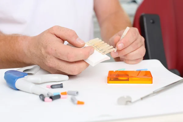 Doctor Holding Dental Teeth Shades Samples At Desk — Stock Photo, Image