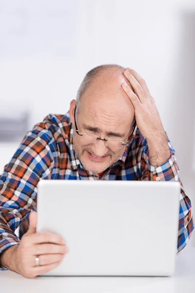 Irritierter Geschäftsmann blickt auf Laptop — Stockfoto