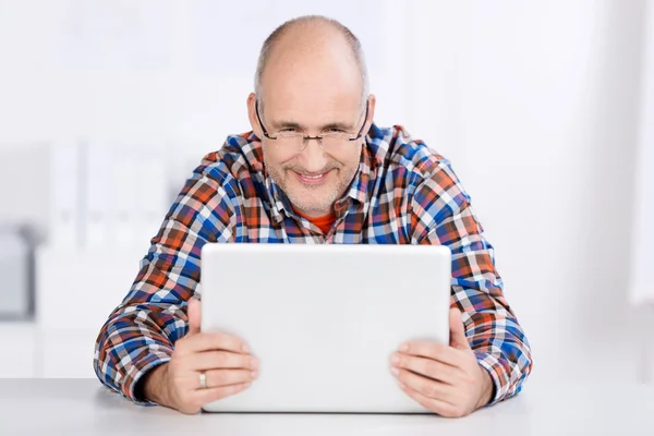 Sitting mature man looking at a laptop screen — Stock Photo, Image