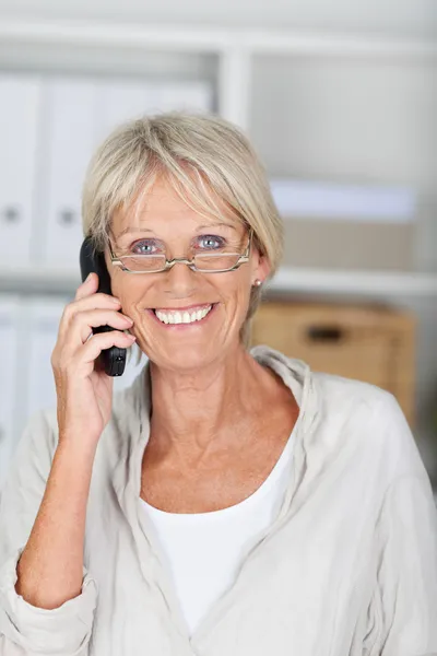 シニア女性実業家のオフィスのコードレスの電話での会話 — ストック写真