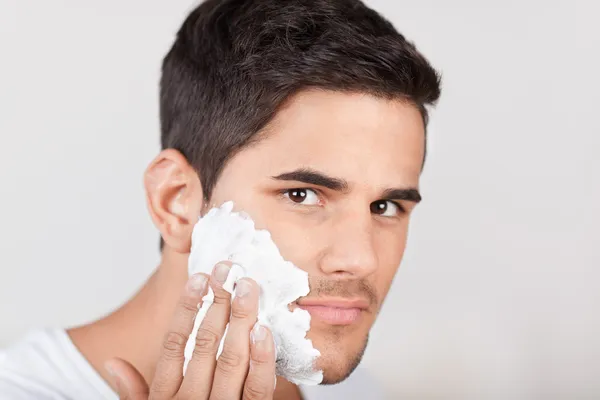 Young Latino man applying shaving cream — Stock Photo, Image