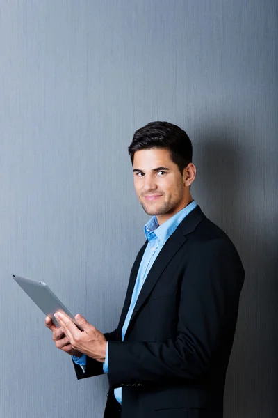 Um empresário segurando um computador tablet — Fotografia de Stock