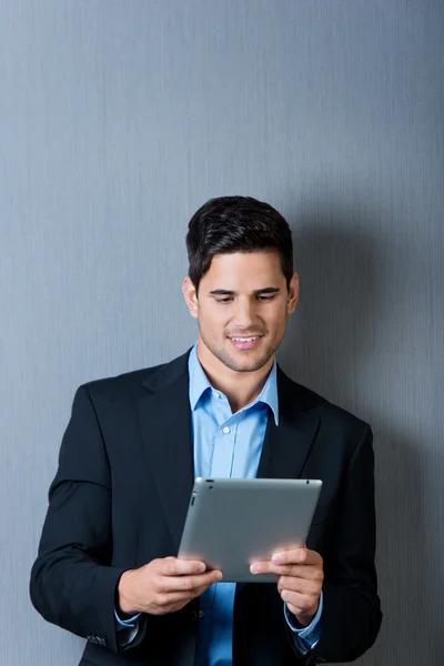 Empresário usando mesa digital contra parede azul — Fotografia de Stock