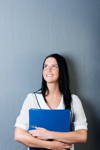 Affärskvinna hålla binder mot blå vägg — Stockfoto