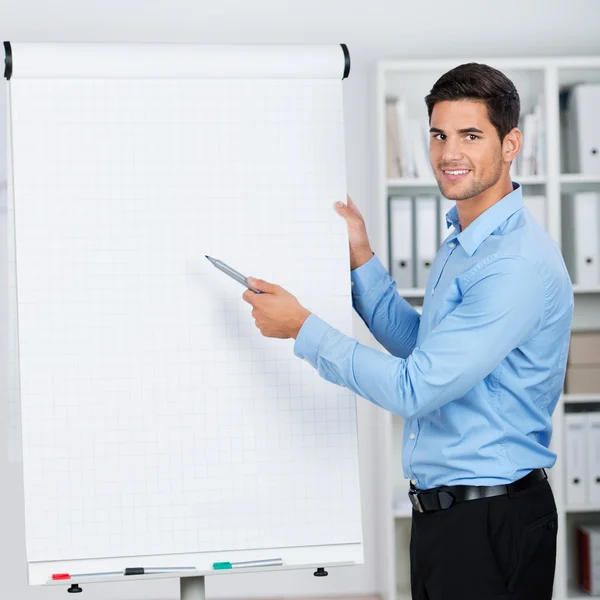 Geschäftsmann präsentiert lächelnd ein Flipchart — Stockfoto