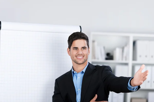 Uśmiechający się przystojny biznesmen w pobliżu tablicę typu flip-chart — Zdjęcie stockowe
