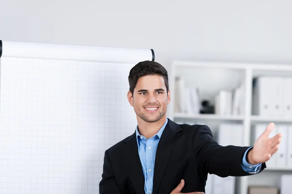 Un hombre de negocios guapo sonriente cerca de un rotafolio — Foto de Stock